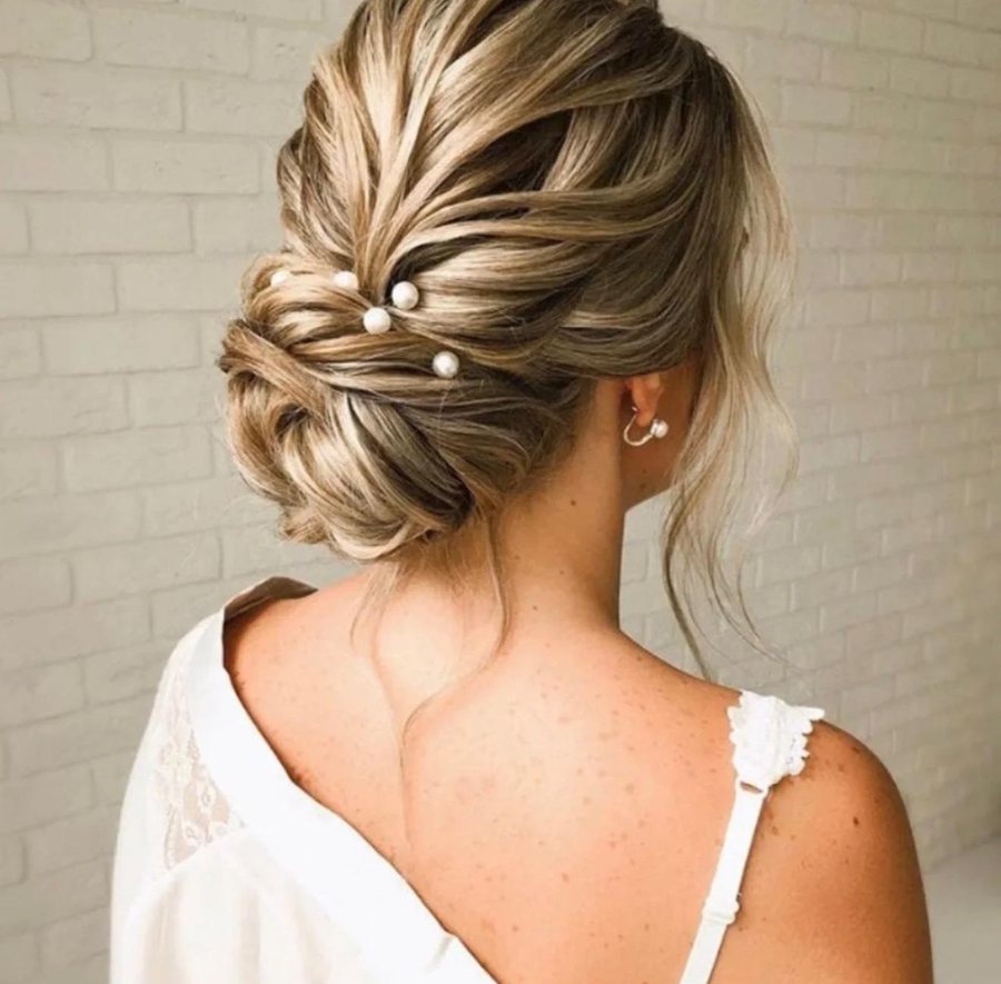 A pearl-pinned bridal updo styled on location